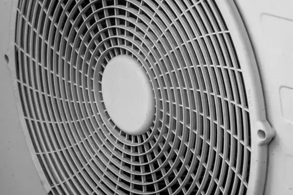 Close-up of a circular fan with a protective grille.