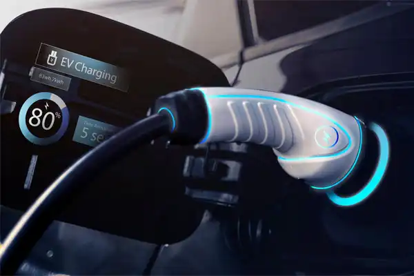 Close-up of an electric vehicle charging port with a plugged-in charger. A display shows 80% charge level.